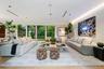 Open-concept living space featuring wood-finish flooring, recessed ceiling lighting, linear air diffusers, and expansive floor-to-ceiling windows