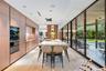 Kitchen featuring floor-to-ceiling wood-finish cabinetry, central island with stone countertop, recessed lighting, and full-length glass sliding doors