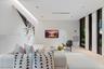 Contemporary interior featuring smooth wall panels, light-toned wood-finish flooring, recessed ceiling lighting, and floor-to-ceiling windows with dar