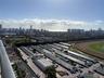 Elevated perspective featuring coastal city skyline, ocean horizon, and racetrack grounds