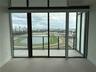 loor-to-ceiling glass windows, ceramic tile flooring, and a glass-paneled balcony overlooking the racetrack and city skyline