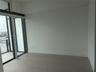 Floor-to-ceiling glass panel windows, large-format tile flooring, and exterior balcony access