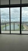 Floor-to-ceiling glass panel windows, sliding glass door, neutral large-format tile flooring, and private balcony featuring a glass railing