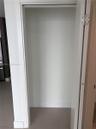 Closet featuring white painted interior, clean-lined door frame, and large-format neutral tile flooring