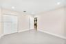 Neutral-toned interior room featuring recessed lighting, a three-panel door, and a white bi-fold closet