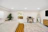 Neutral-toned room featuring recessed ceiling lighting, light-colored tile flooring, and integrated access to a bathroom with a double-sink vanity and