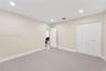 Neutral-toned room featuring recessed lighting, smooth-finish flooring, and a multi-panel door closet with white finish