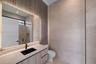 Floating vanity with integrated countertop, rectangular black vessel sink, matte black faucet, and vertical wood-texture wall paneling with recessed L