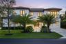 Two-story contemporary exterior featuring a smooth stucco finish, dark-framed multi-pane windows, a tiled roof, and a paved geometric driveway