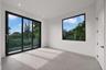 Large-format ceramic tile flooring, floor-to-ceiling sliding glass doors with black frames, oversized picture window, and recessed ceiling lighting