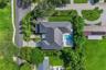 Overhead aerial showing the home, pool, and generous lot within a mature tree canopy