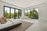 Open-concept interior featuring large-format tile flooring, recessed ceiling lighting, tray ceiling details, and floor-to-ceiling glass sliding doors 
