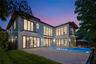 Twilight view of the backyard, pool, and expansive lawn