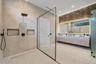 Walk-in shower with a glass enclosure, dual rainfall showerheads, and dual built-in wall niches