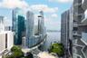 Private balconies with glass railings overlooking a waterfront cityscape and public green space
