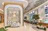 Grand lobby featuring floor-to-ceiling windows, arched architectural detailing with wood-finish paneling, a textured stone reception desk, integrated 