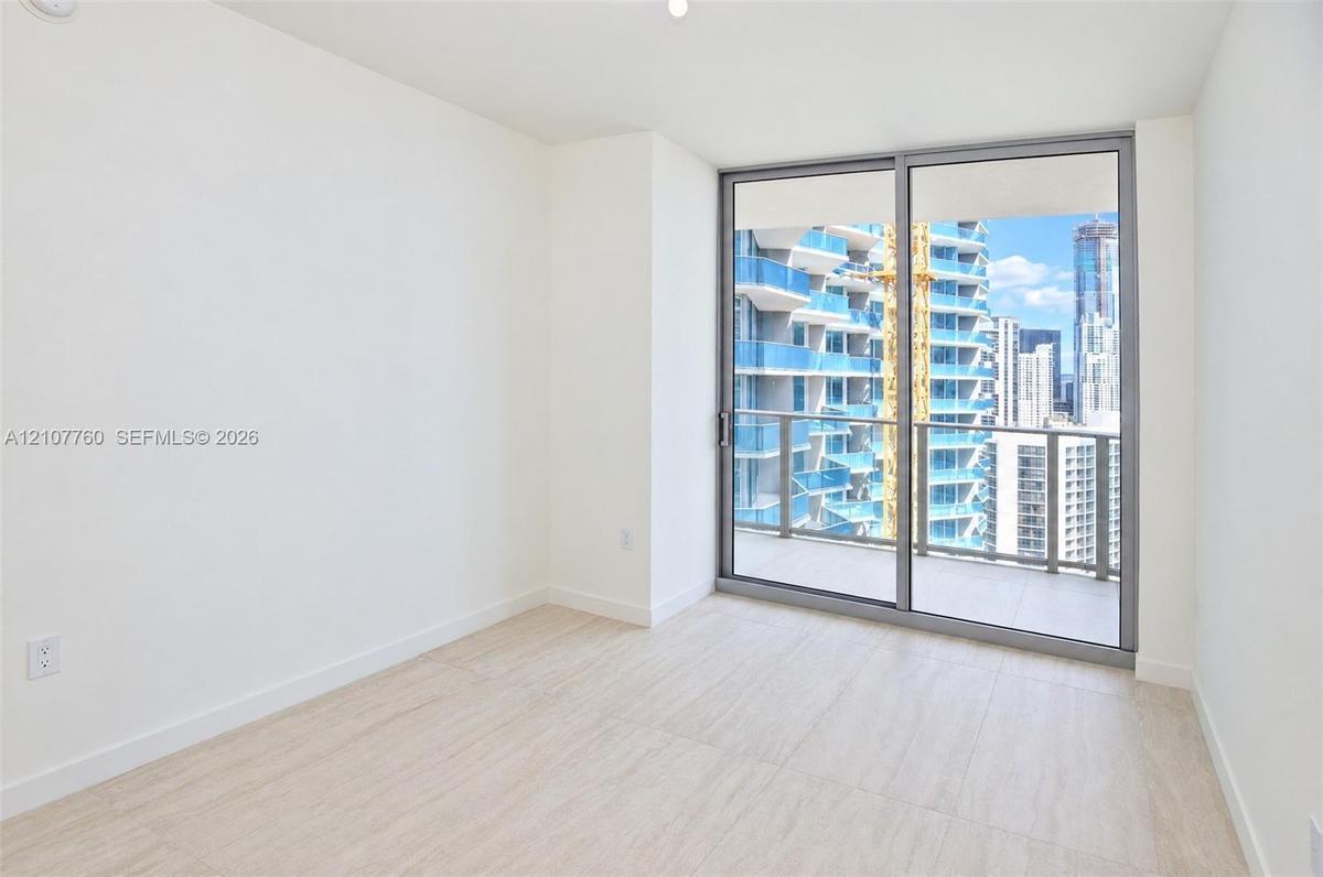 Interior space featuring wood-finish flooring, floor-to-ceiling sliding glass doors, and a private balcony