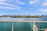 Balcony featuring a glass panel railing and panoramic waterfront and city skyline scenery