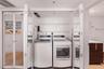 Laundry closet featuring white bifold mirrored doors and built-in wire shelving