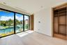Floor-to-ceiling glass paneling, light wood-finish flooring, recessed lighting, and custom built-in wood closet shelving