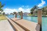 Waterfront dock featuring composite decking, integrated piling covers, and a paved concrete approach