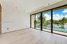 Light-filled room featuring wood-finish flooring, recessed lighting, and floor-to-ceiling multi-panel sliding glass doors with access to a balcony wit