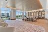 Expansive open-concept space featuring a wood-plank tray ceiling with integrated cove lighting, floor-to-ceiling glass paneling, wood-finish flooring,