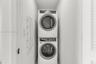 Stacked white front-load washer and dryer unit with digital control panels