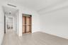 Wood-finish flooring, sliding door closet with built-in wooden shelving, and recessed ceiling lighting