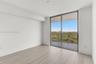 Light-filled room featuring wood-finish flooring, floor-to-ceiling sliding glass doors, and a private balcony with metal railings