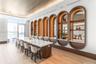 Extended island featuring a stone-style countertop, integrated arch-framed shelving with recessed lighting, mirrored backings, wood-finish flooring, a