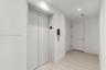 Elevator access with flat-panel doors, light-toned wood-finish flooring, and recessed LED ceiling lighting