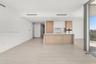 Kitchen featuring two-tone wood-finish and white cabinetry, stone-finish backsplash, built-in stainless steel appliances, and a central island with a 