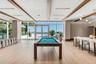 Common area featuring floor-to-ceiling windows, wood-finish tile flooring, recessed lighting, and wood-beam ceiling accents