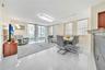 Open-concept living space featuring high-gloss tile flooring, floor-to-ceiling glass doors, built-in breakfast bar, contemporary crystal chandelier, a