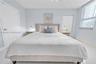 Bedroom featuring white tile flooring, vertical window blinds, and dual interior paneled doors