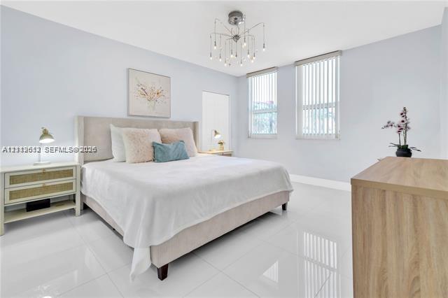 Room featuring glossy tile flooring, vertical blinds, and a multi-arm modern chandelier