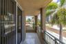 Covered balcony featuring tile flooring, metal railings, and a stucco ceiling