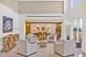 High-ceiling interior space featuring stone flooring, linear recessed lighting, and expansive floor-to-ceiling windows