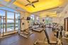 Fitness center featuring expansive floor-to-ceiling windows, tray ceilings with recessed lighting, and industrial ceiling fans
