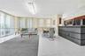 Open-concept interior featuring large-format tile flooring, a kitchen breakfast bar with wood-finish cabinetry, built-in stainless steel appliances, a