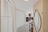 Interior area featuring high-gloss tile flooring, white bi-fold closet doors, and recessed ceiling lighting