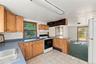 Kitchen featuring light-finish wood cabinetry, solid-surface countertops, tile flooring, built-in breakfast bar, and sliding glass exterior door