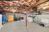 Unfinished basement space featuring exposed joists, painted concrete block walls, concrete floor, support columns, and dedicated laundry hookups