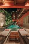 Rectangular pool featuring stone-clad walls, exposed beam ceiling, stone flooring, and built-in louvered shutters