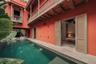Courtyard featuring a swimming pool, stone tile decking, exposed wood beam ceiling, tiered wooden balcony, and louvered shutter doors