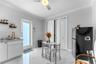 Polished tile flooring, built-in lower cabinetry with stone-finish countertops, undermount sink with brass-finish faucet, bi-fold closet doors, and ex