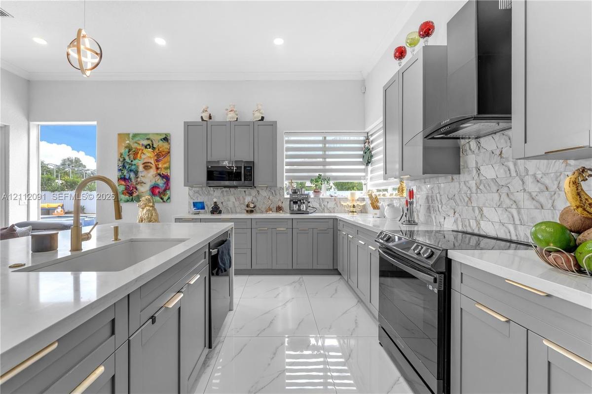 Kitchen featuring gray Shaker-style cabinetry, white solid-surface countertops, stone-tile backsplash, stainless steel appliances, and large-format po