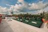 Rooftop terrace featuring natural stone tile flooring, a tiered concrete platform, an outdoor shower, and a built-in privacy wall with decorative bree