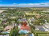Aerial perspective of a residential property featuring a tile roof, an in-ground swimming pool with an attached spa, and a concrete driveway
